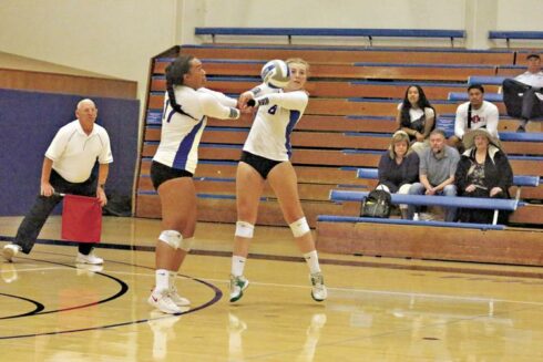 CSM sophomore Naomie Cremoux, right, digs a ball with freshman Tui Saluni backing up Saturday in San Mateo. Photo by Terry Bernal.
