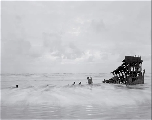 A photograph of the wreckage of the Peter Iredale, a steel ship that departed Santa Cruz, Mexico, bound for Oregon, and ran aground in 1906. Photo by Richard Lohmann.