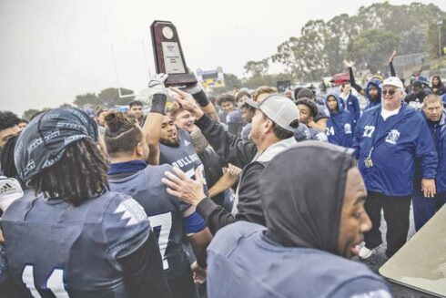 The College of San Mateo Bulldogs hoist the CCCAA Northern California championship trophy Saturday at College Heights Stadium after a 30-5 win over American River. Photo by Patrick Nguyen.