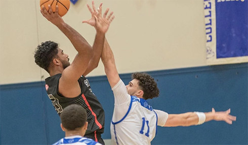 Skyline freshman Milandev Chatha, left, shoots against CSM sophomore Jack Busenhart in a Feb. 21 men’s basketball matchup in San Mateo. Photo by Ron Rugel.